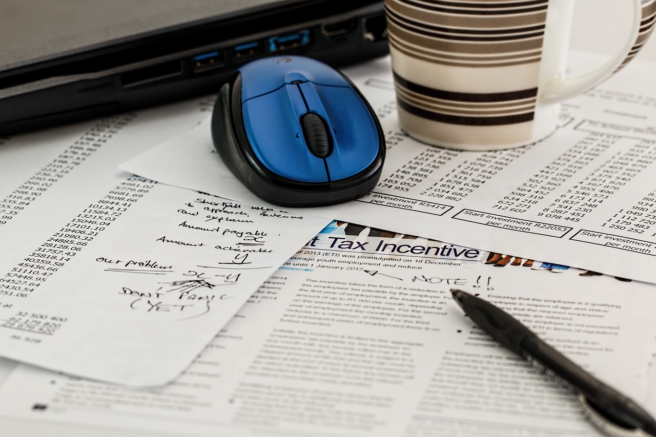 Tax forms, ouse, cup and a laptop. Image by Pixabay