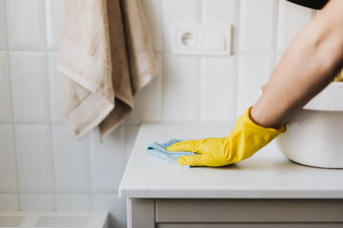 Cleaning sink area. Yellow gloves