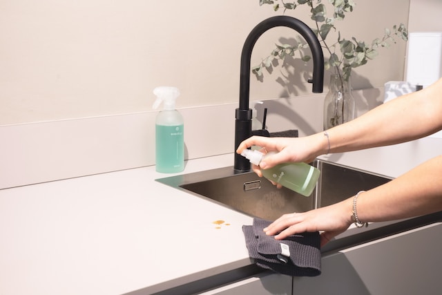 Person cleaning a sink and counter