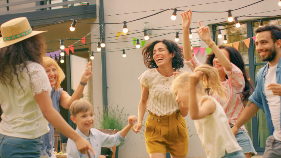 People dancing in a backyard. Stringlights hanging