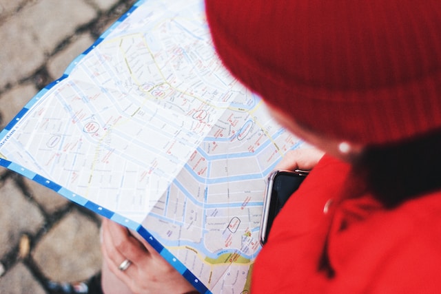 person with a red hat looking at a map