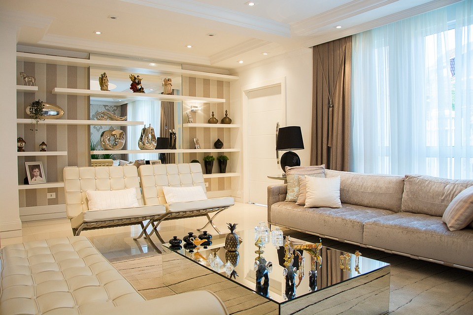 Livingroom, white shelving on walls, tan leather seating, sofa, mirror table with accessories on it