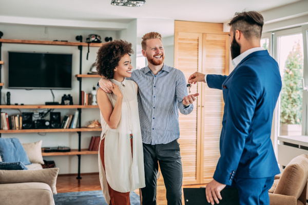 Person handing over keys to a couple