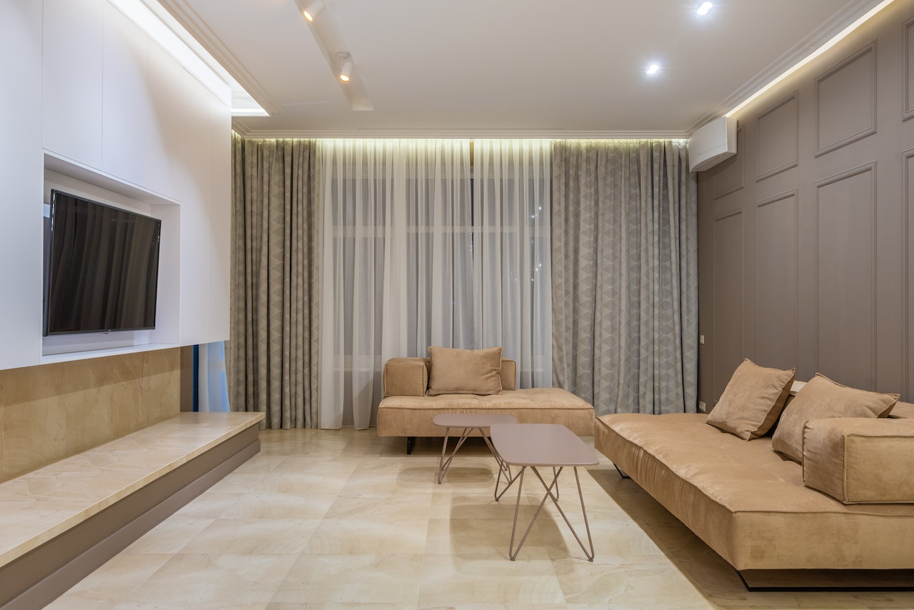 livingroom, beige sofas, tables, tv on wall