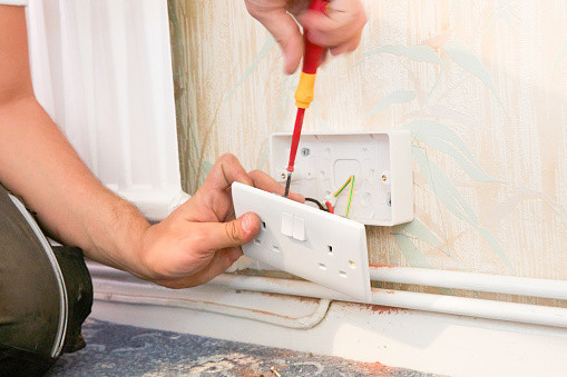 Person rewiring an outlet