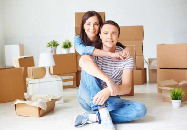 Boxes on the floor, 2 people sitting on the floor