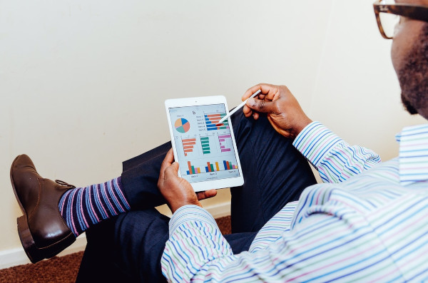 person sitting with a tablet looking at marketing analytics