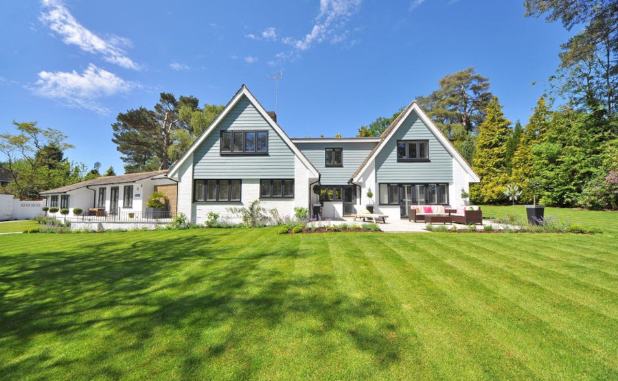 Get a family house that offers you the features you're looking for! A white and blue house surrounded by grass and trees