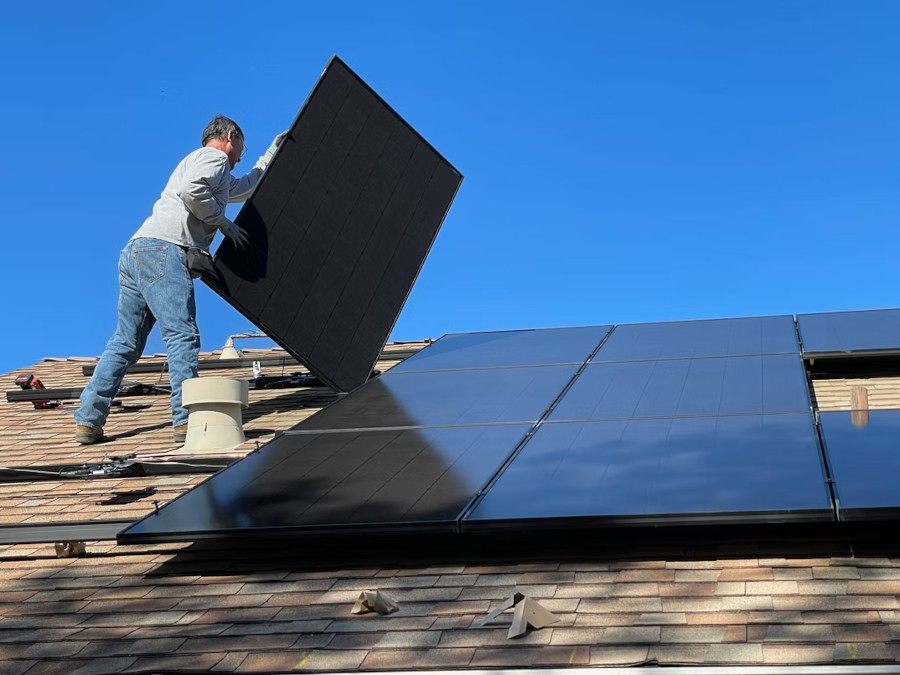 person installing solar panels on a roof