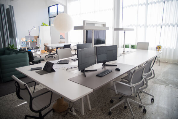 office, large table with computer monitors