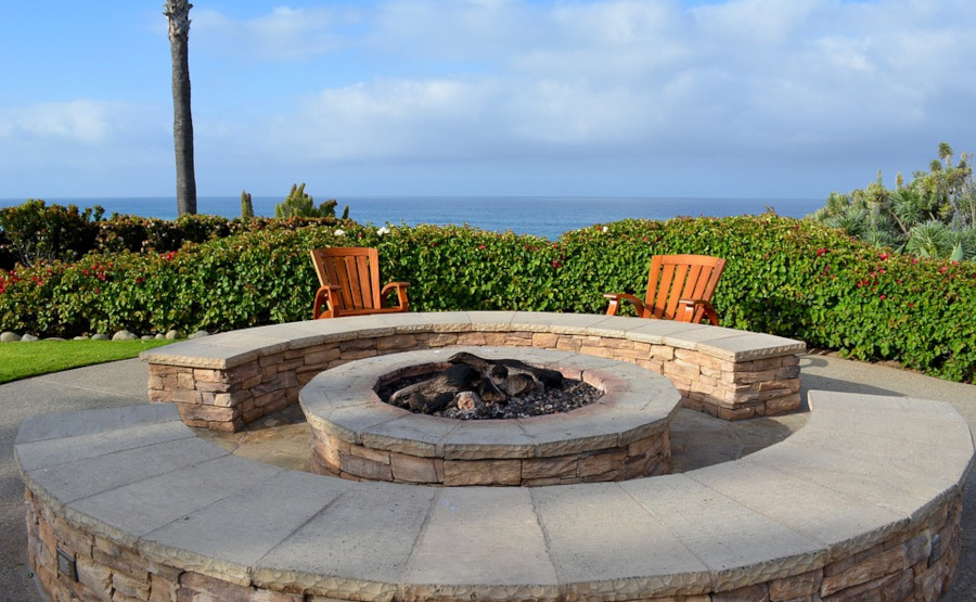 Stone firepit on lawn facing the ocean