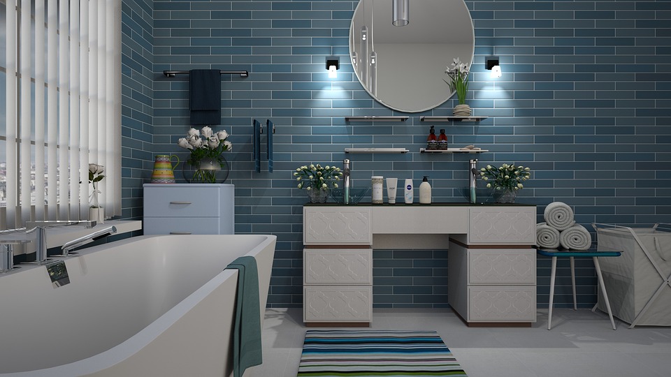 Bathroom with blue tile on the wall, bathtub, mirror, plants.