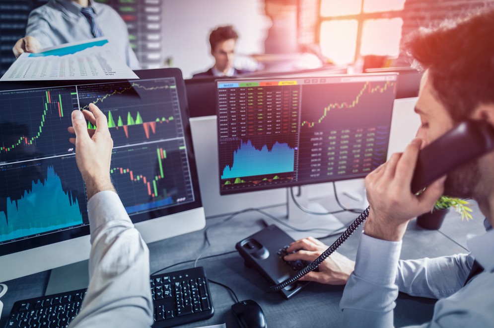 multiple computer screens with stock charts
