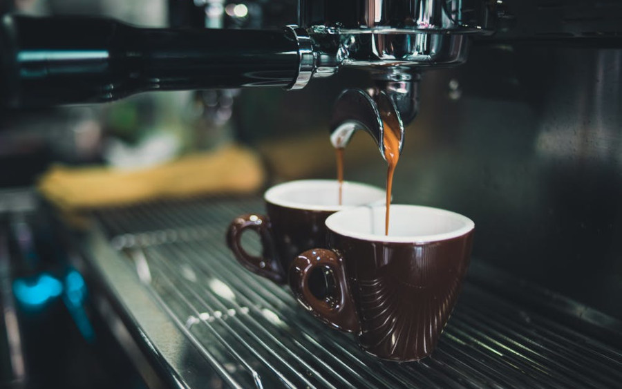 Coffee being poured into two mugs