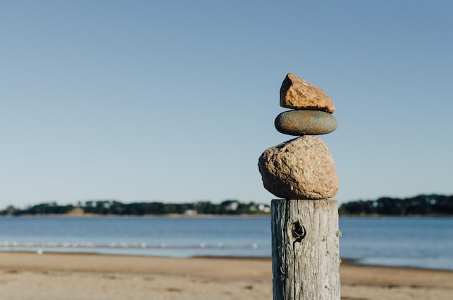 rocks balances on a post, ocean, beach