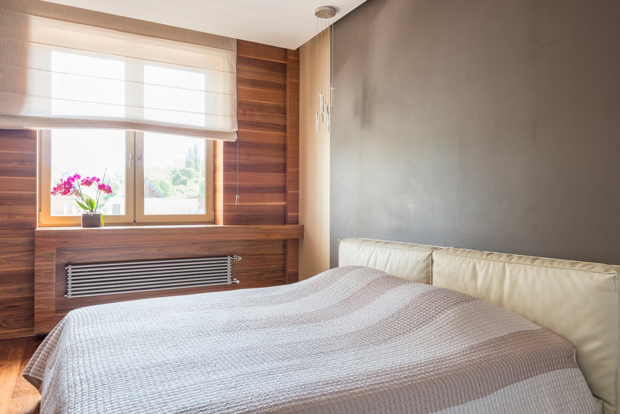 Bedroom with a grey wall and a wooden wall. Image by Pexels