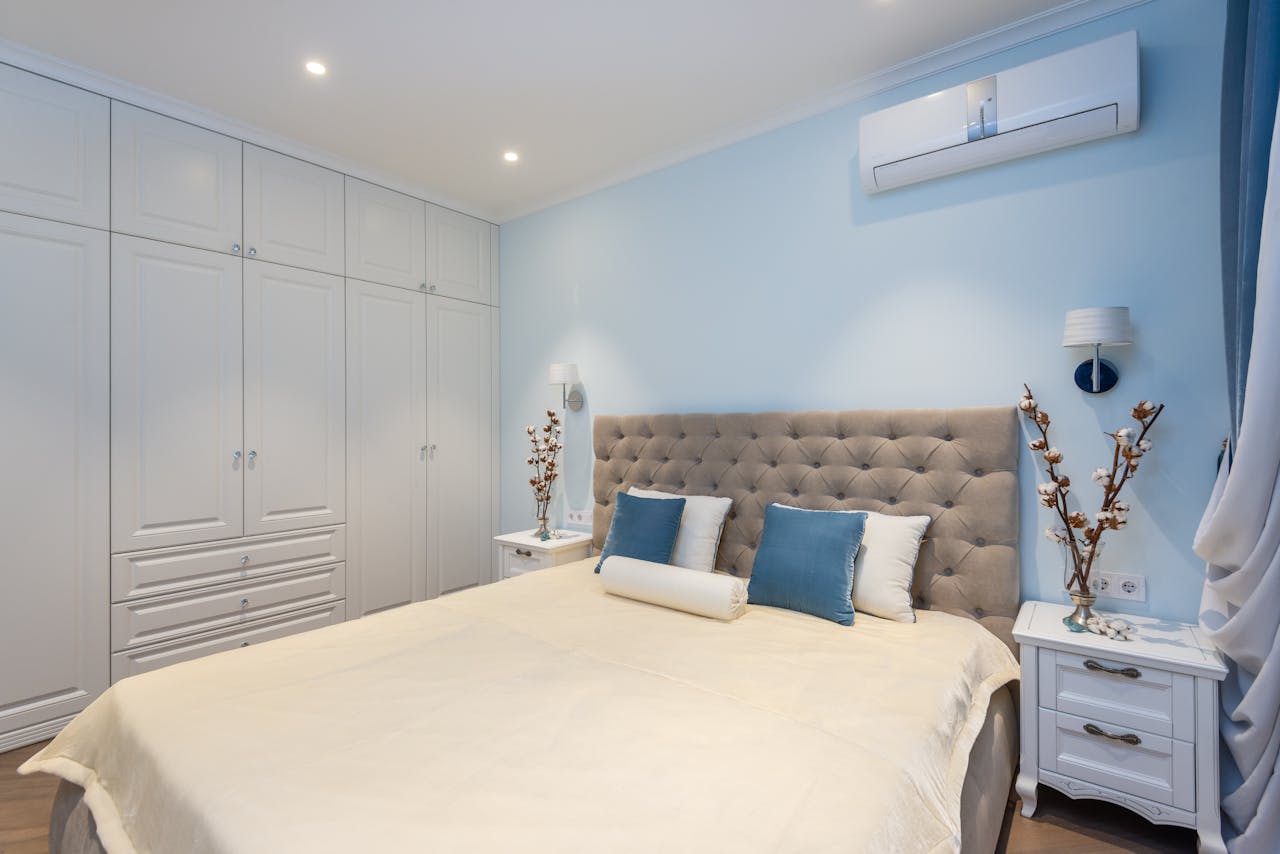 Bedrom with large white closet. A/C unit on wall. Image by Pexels