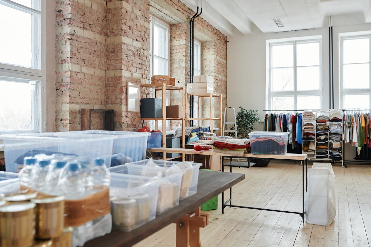 Boxes and clothes stacked inside a small apartment storage room. Image via Pexels