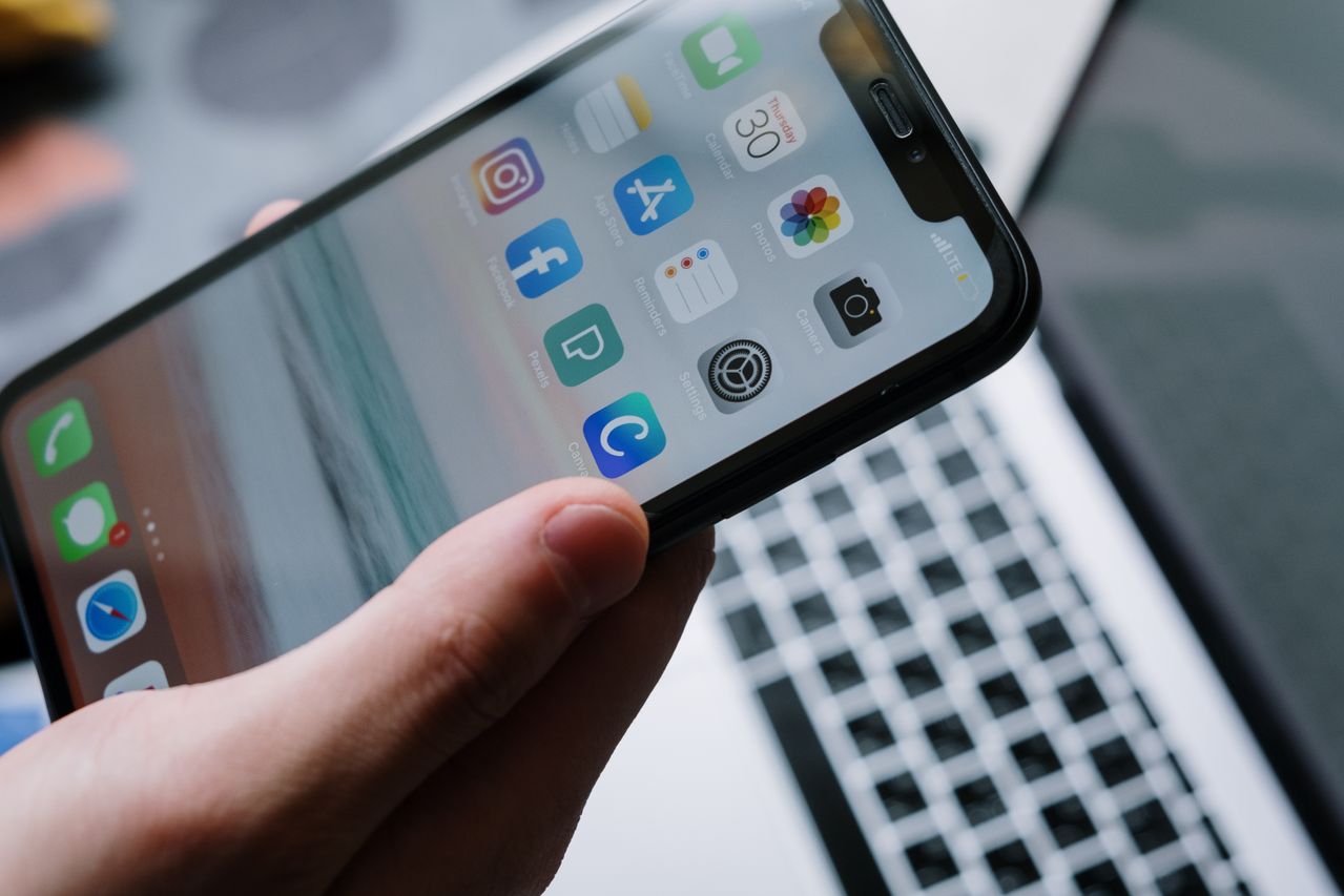 Holding a smartphone with apps. Photo Pexels