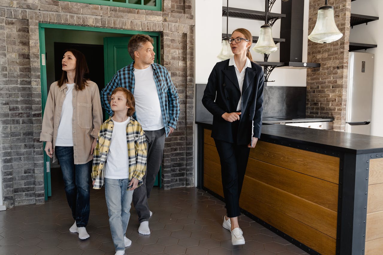 A real estate agent touring a family inside a house. Image by Pexels