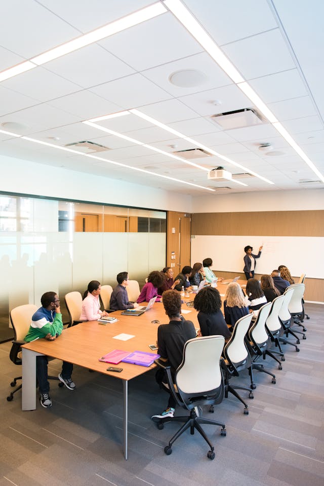 People sitting around a table in a meeting. Image by Pexels