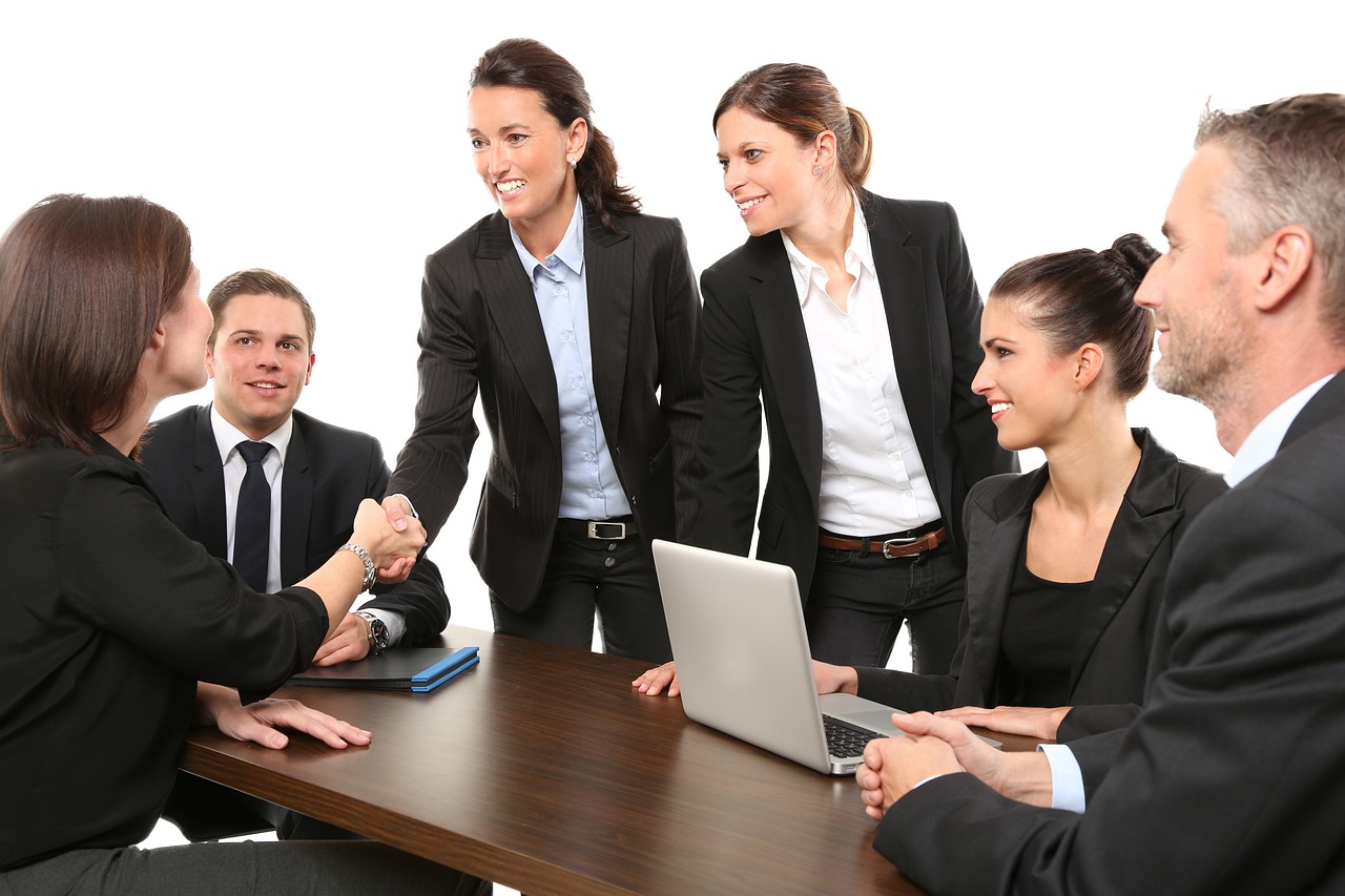 People sitting around a table in a meeting. Image by Pexels