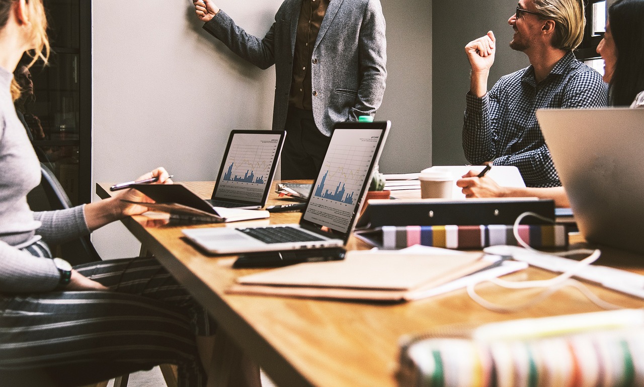 People in  a meeting, laptops on a table. Image by Pixabay