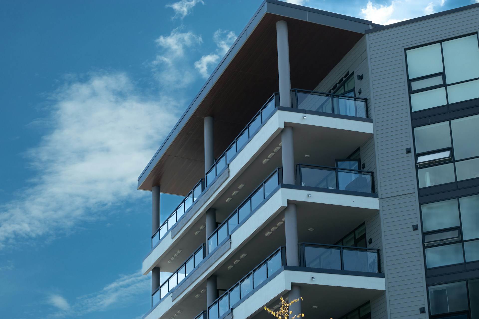 Tall building with lits of balconies and windows. Image by Unsplash