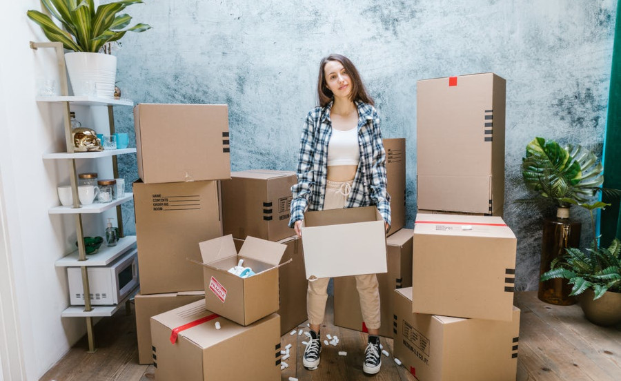 Person surrounded by boxes and holding a box