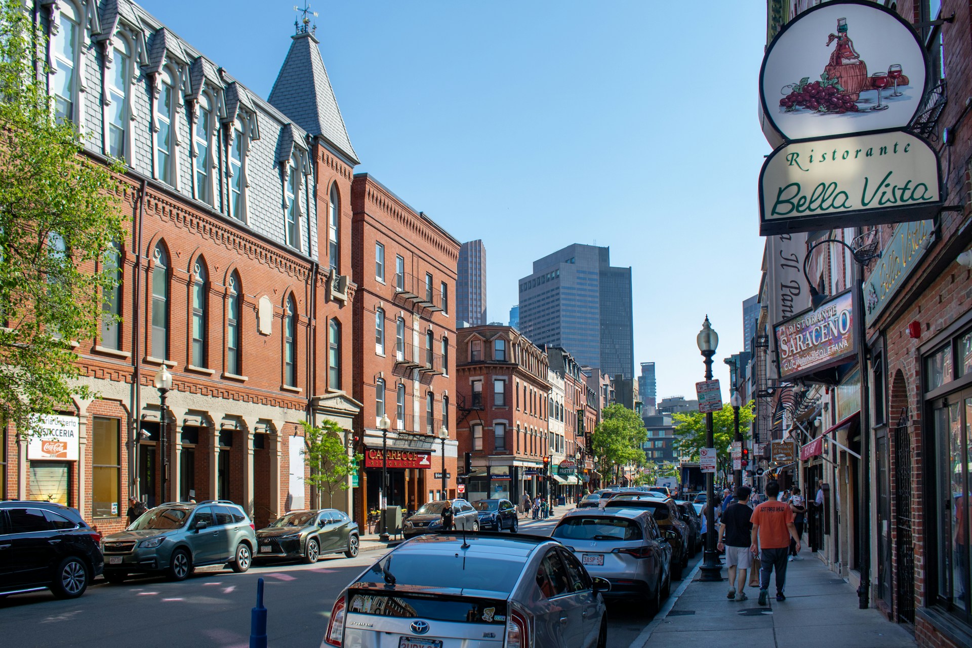 City street lined with parked cars and tall buildings in Boston's North End