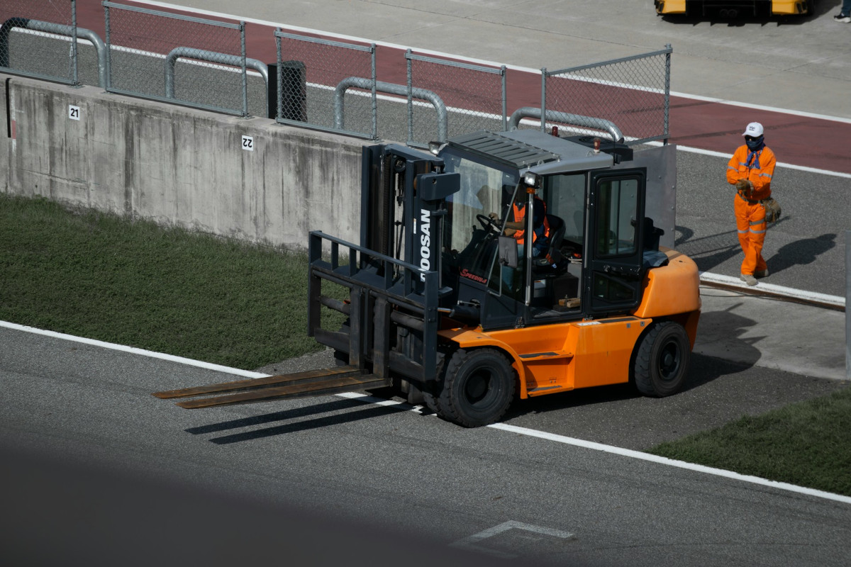 A forklift driving our of a driveway. Image by Unsplash