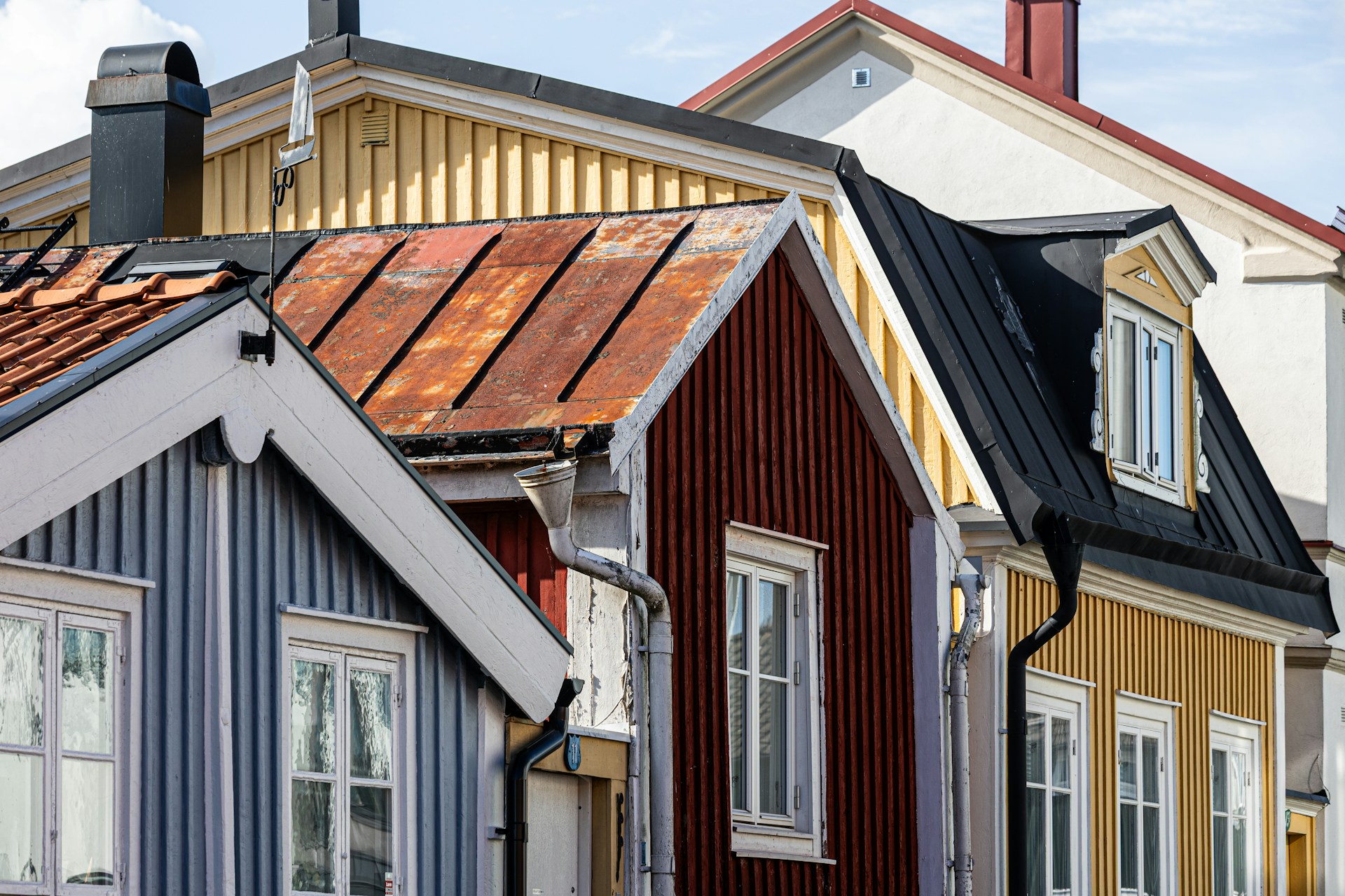 Colorful wooden houses line a street. Image by Unsplash