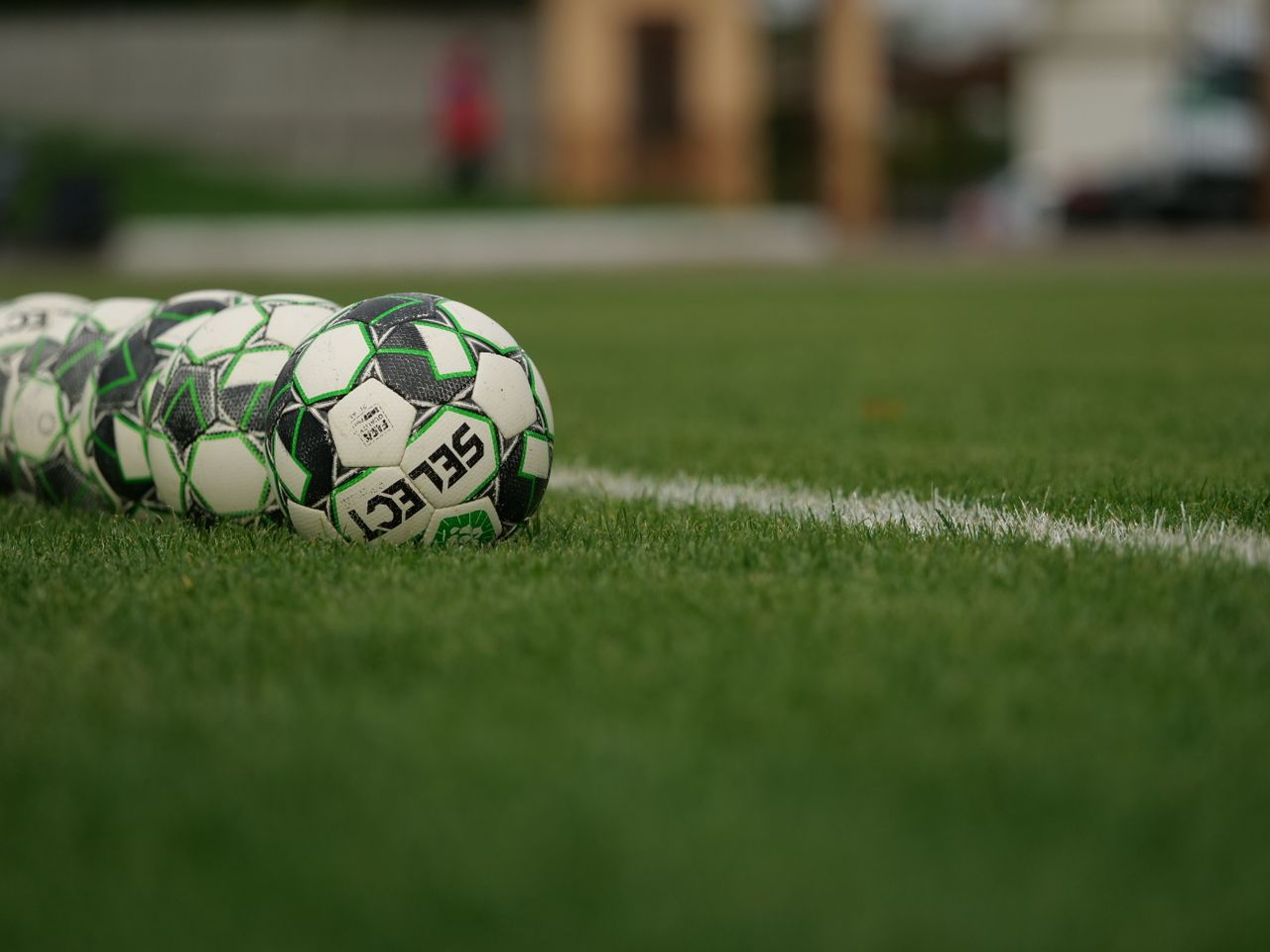 Soccerballs on a grassfield. Image by Pexels