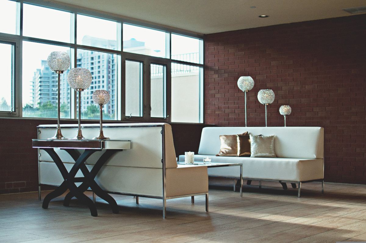 Room with exposed brick wall, sofas, lamps and tables. Image by Pixabay
