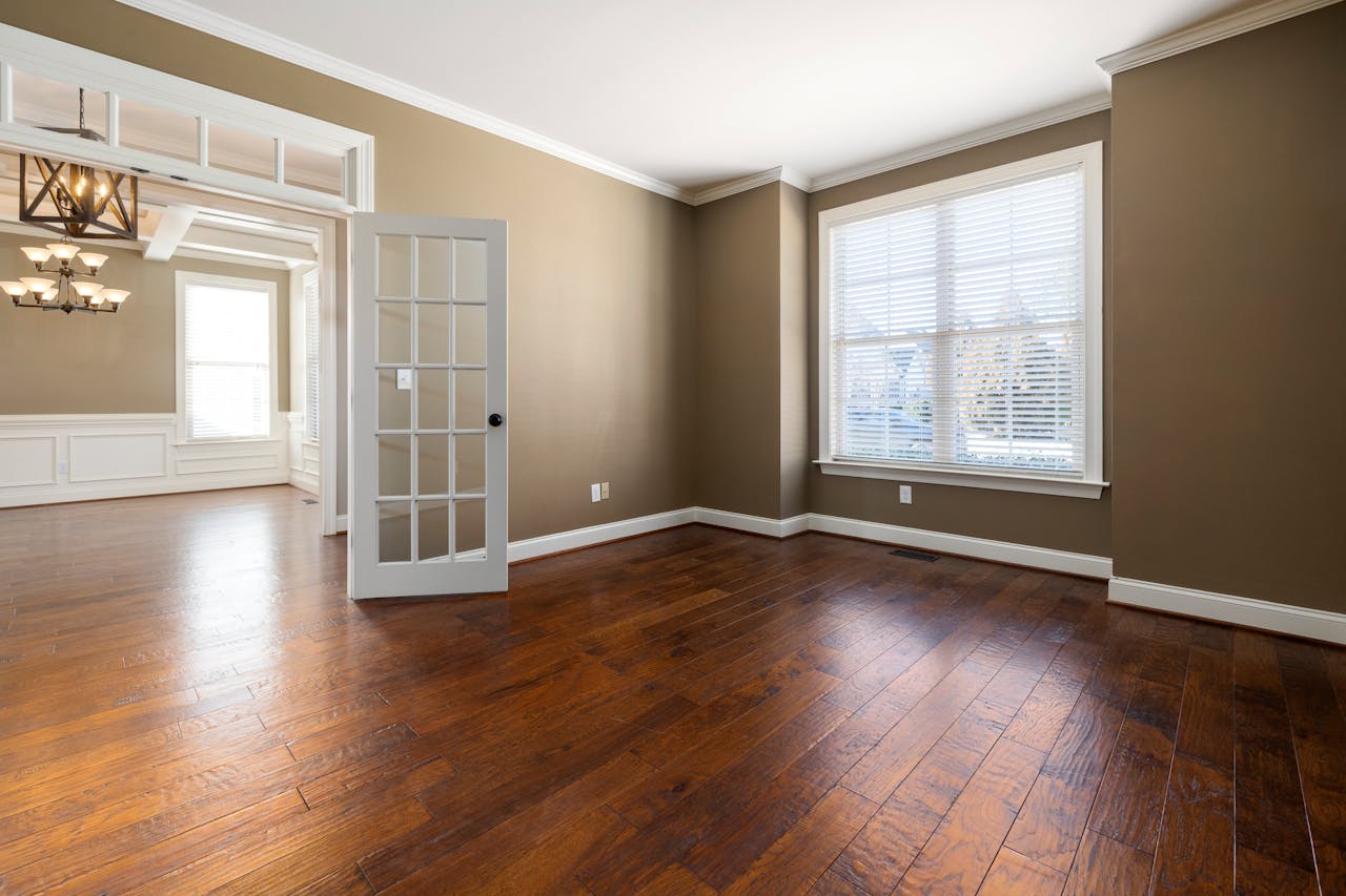 Livingroom, diningroom, hardwood floors, brown walls, white trim. Image by Pexels