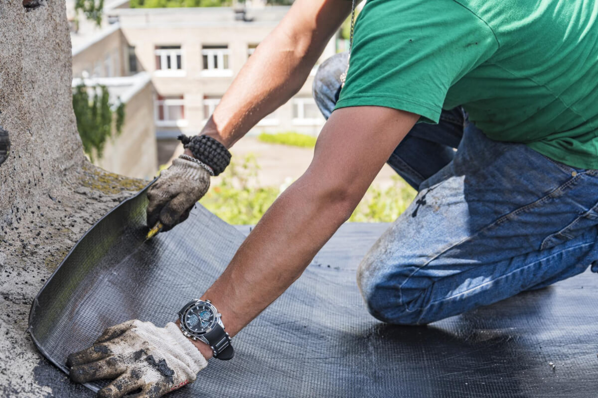 Person working on the roof of a residential building. Image by Freepik