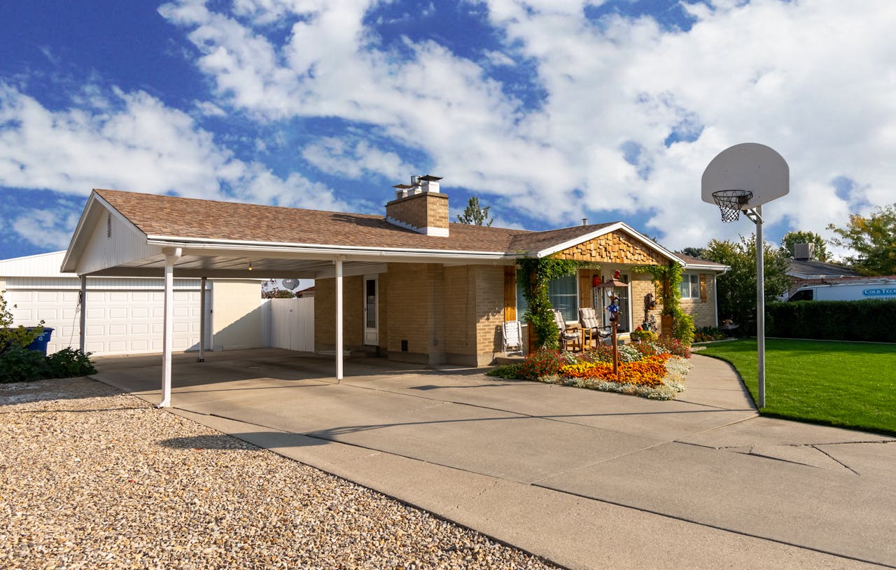 House with a basketball ring in the driveway. Image by Pexels