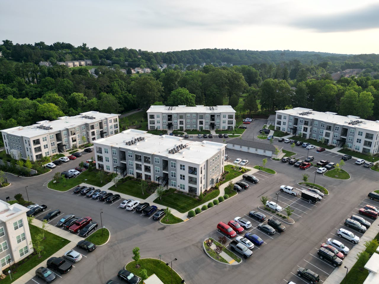Multi-story residential building with adjacent parking lot and landscaped surroundings