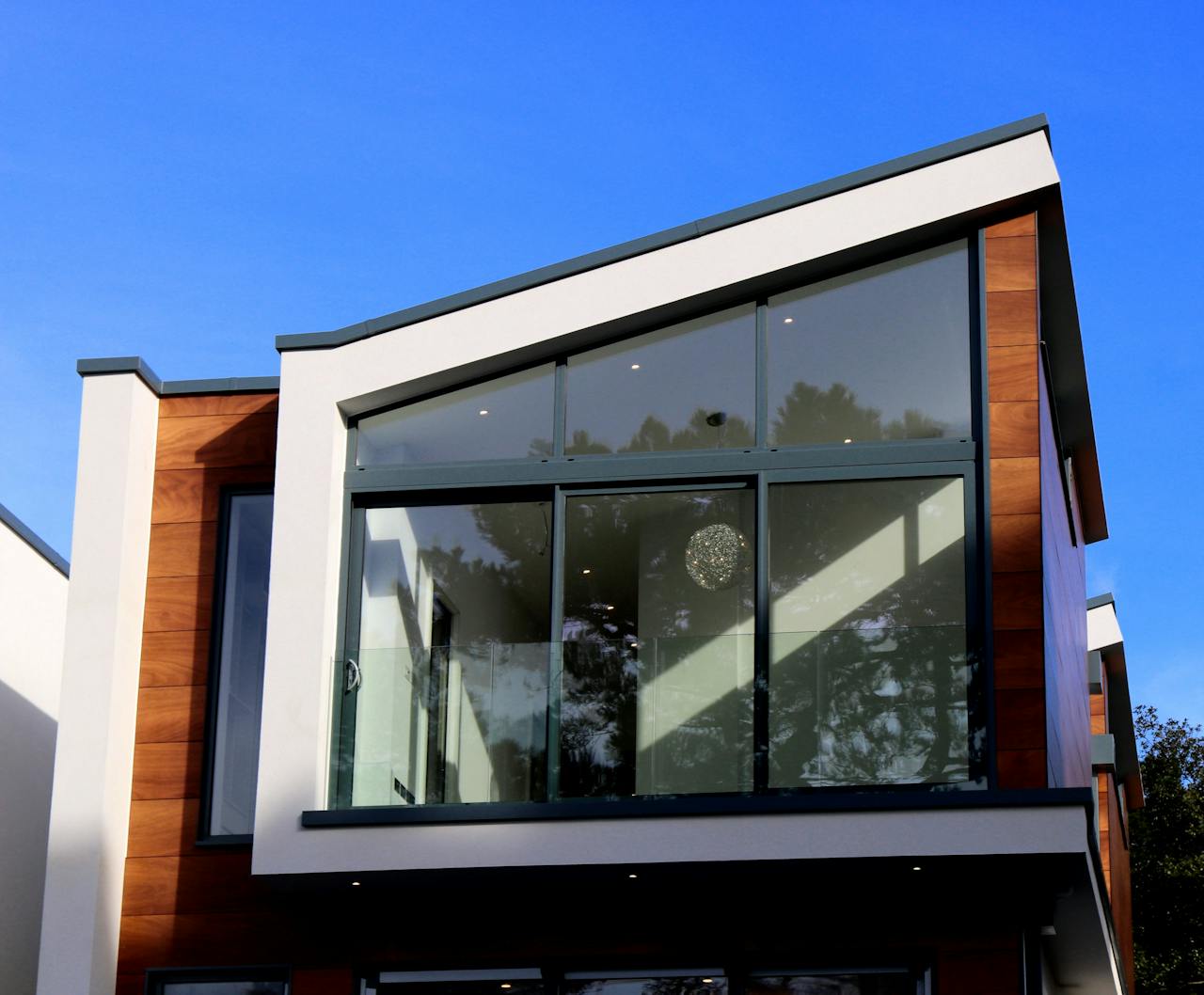 Modern building with large windows, blue sky. Image by Pexels