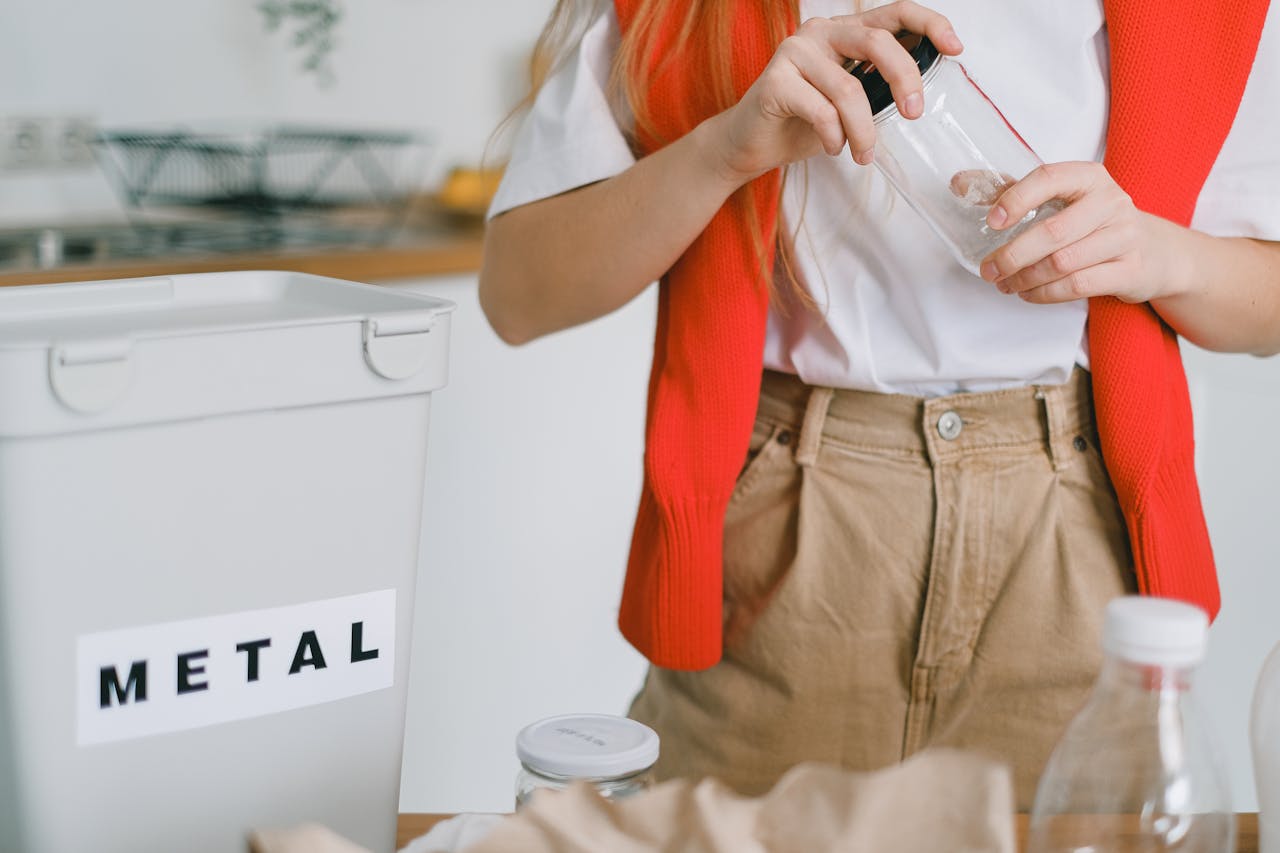 Person unscrewing a lid from a glass jar. Image by Pexels