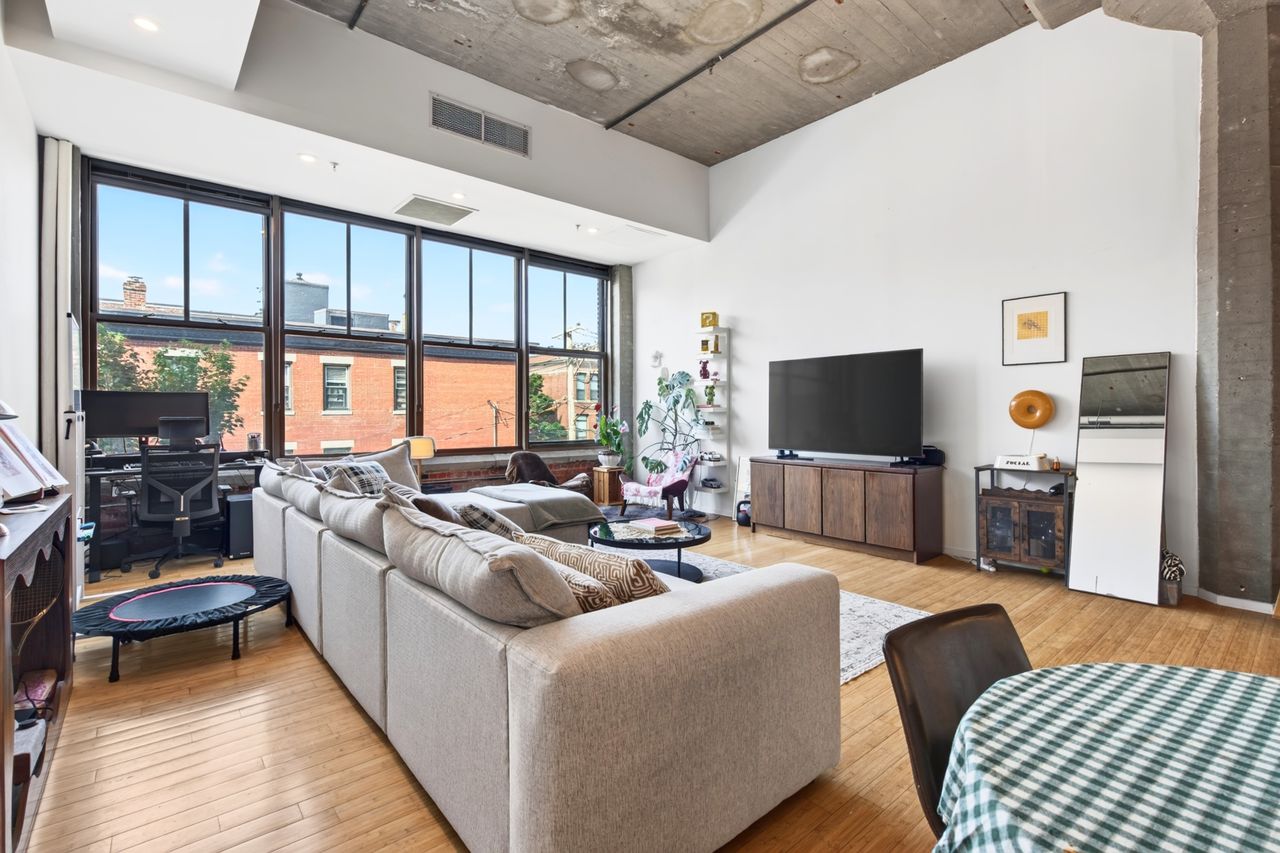 Cozy rental apartment living room with a rug, lamp, and art. Image by Pexels