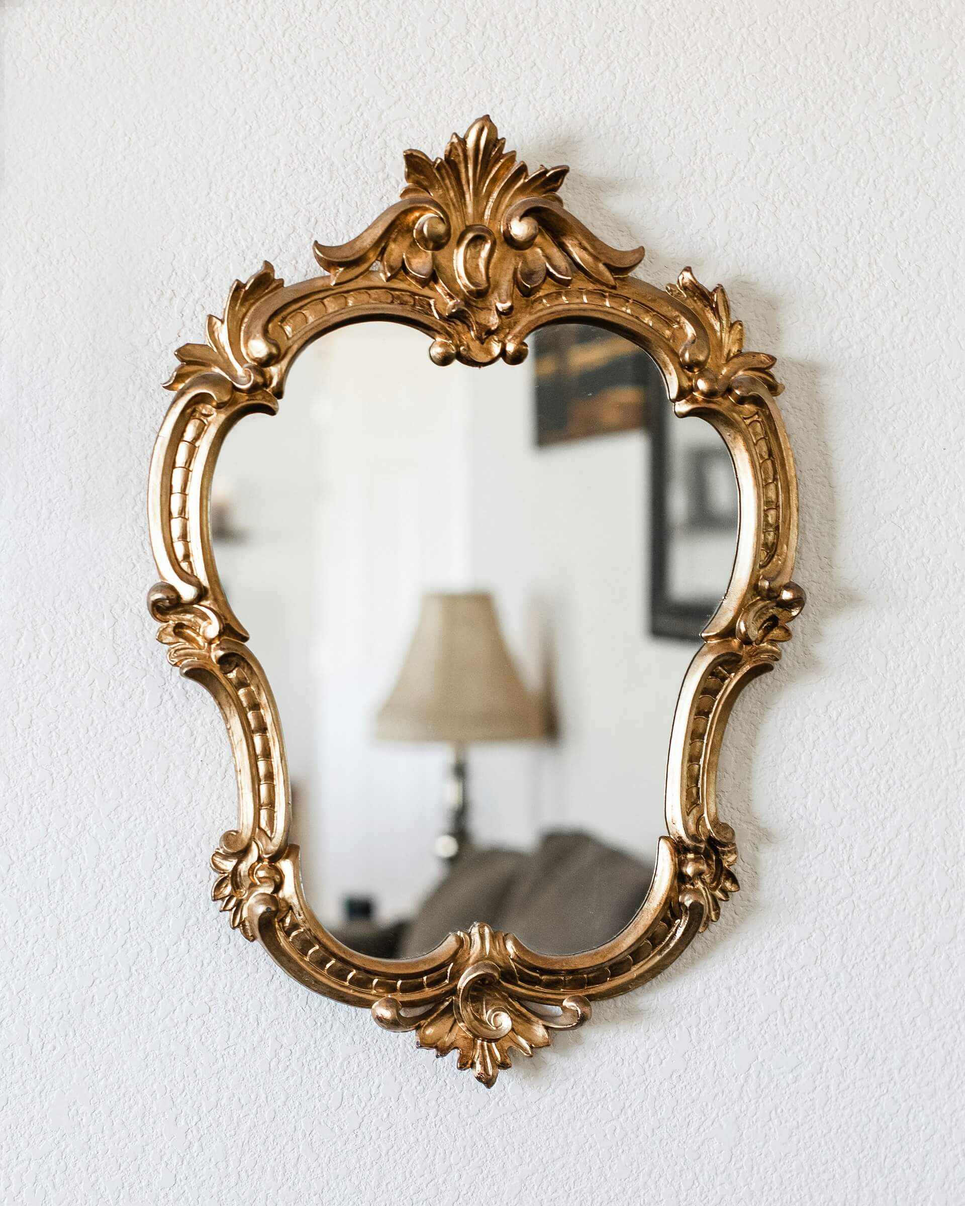 Mirror with a gold frame hanging on a wall. Image by Unsplash