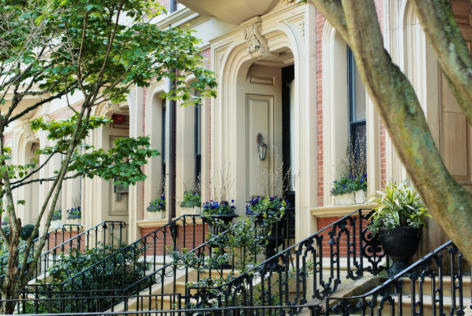 A cozy Boston brownstone interior with exposed brick and large bay windows - unsplash