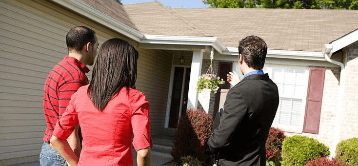 3 people looking at a house