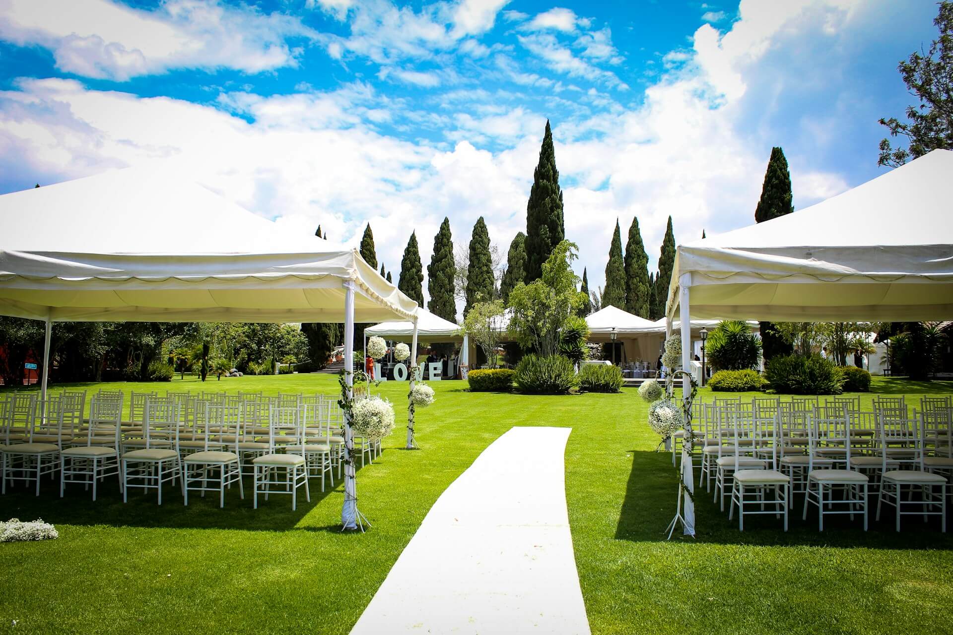 Outdoor Wedding Venue, White tents and white chairs. Image by Unsplash.