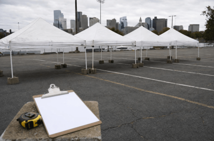 Rows of large frame tents set up as a temporary tent city site