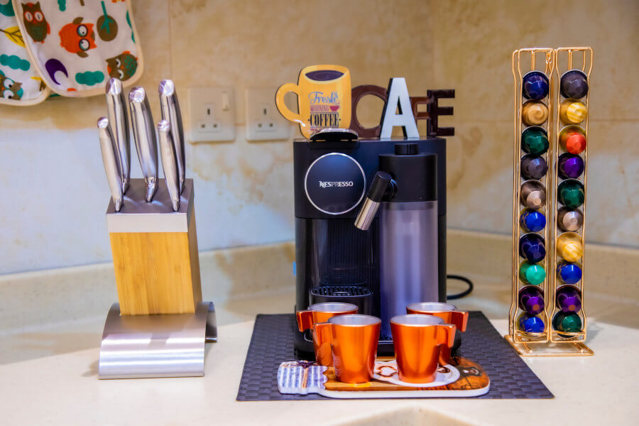 Nespresso machine, coffe mugs, knives, coffee pods