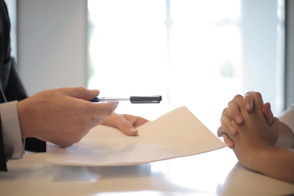 Person holding a pen and paper in his hands.