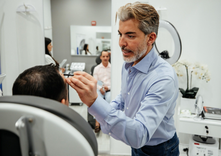 International patient at a hair transplant clinic consultation reviewing a graft plan and hairline design before surgery