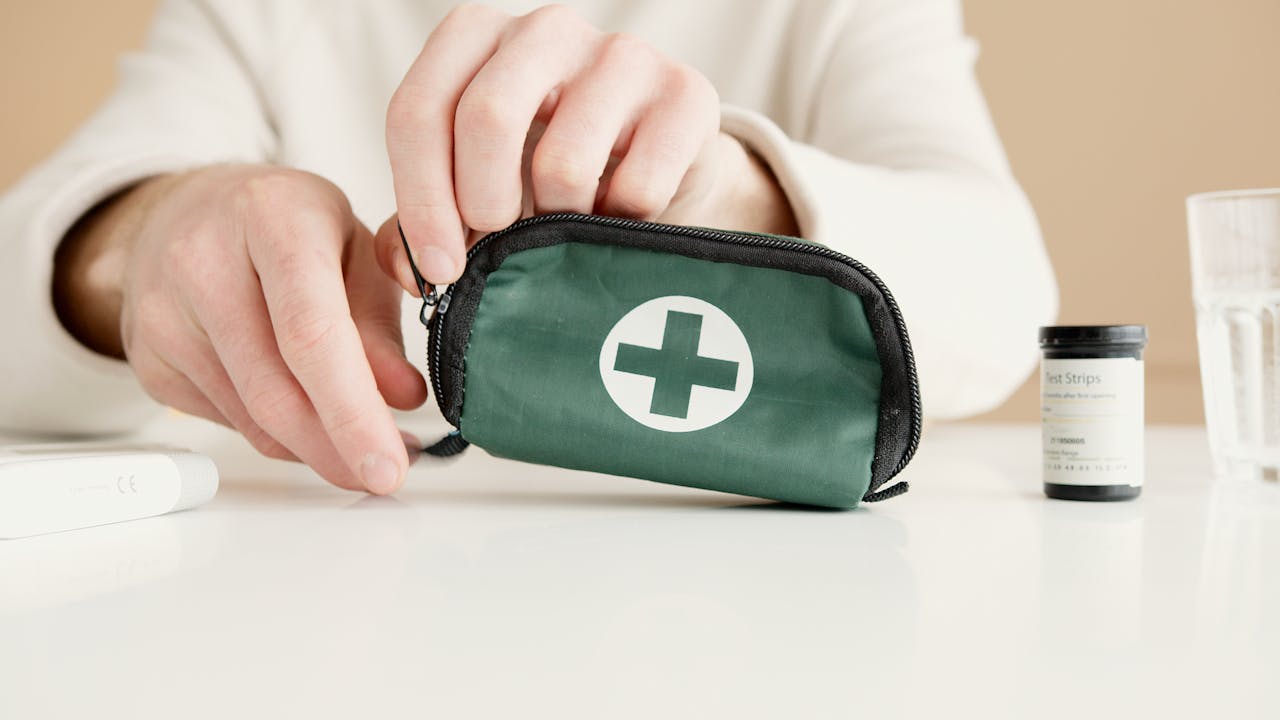 Person holding a green and black medical pouch. Image by Pexels